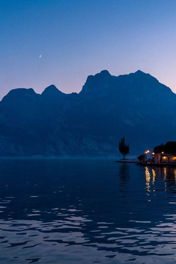 Moonrise over the waterfront restaurants and hotels of Torbole in the north of Lake Garda, Italy