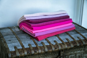 Fashion photography for Esperance and Co shot on location in Palm Beach, NSW, Australia showing a stack of cashmere toppers in shades of pink